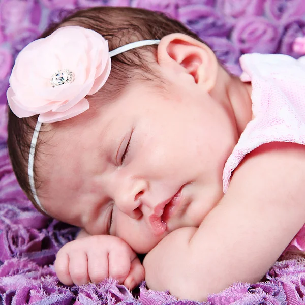 Новорожденная девочка спит на фиолетовом одеяле — стоковое фото