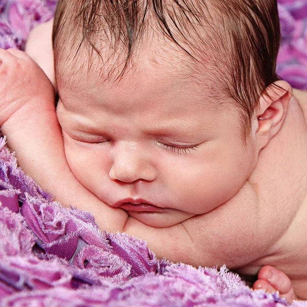 Nyfödd flicka sover på lila filt — Stockfoto