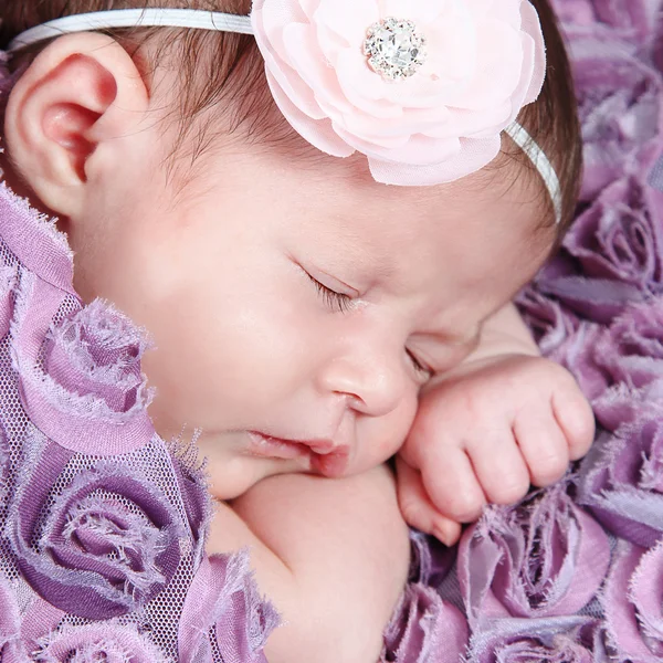 Новорожденная девочка спит на фиолетовом одеяле — стоковое фото