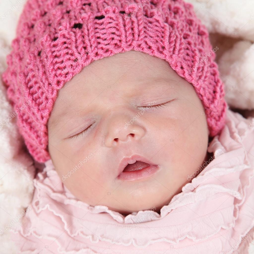 Newborn baby in hat sleeping