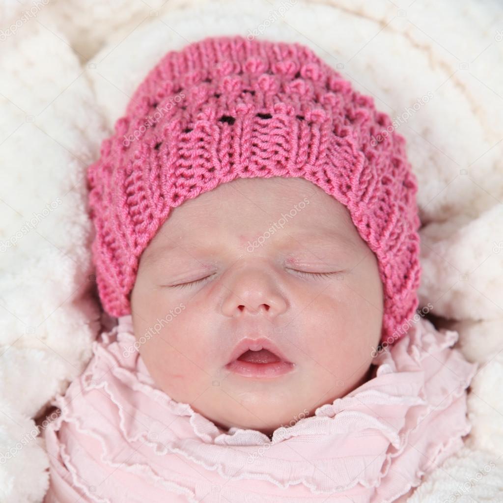 Newborn baby in hat sleeping