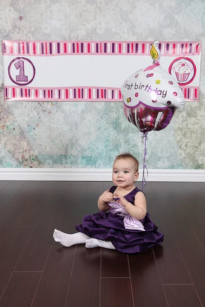 Menina em vestido roxo sentado no chão — Fotografia de Stock