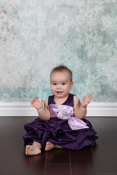 Kleines Mädchen im Kleid sitzt auf dem Boden — Stockfoto