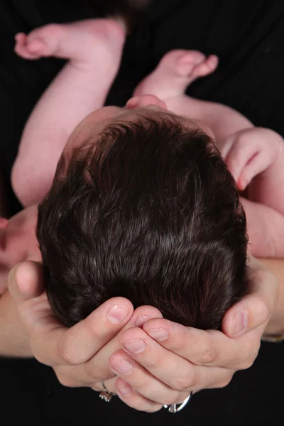 Bebé recién nacido en mano de madre — Foto de Stock