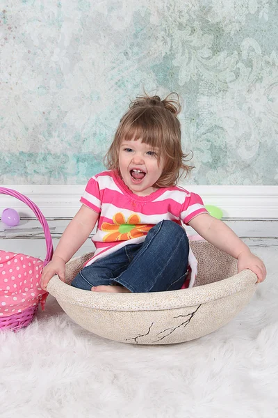 Hermosa niña sentada en la cesta — Foto de Stock
