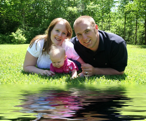 Familia joven junto al agua —  Fotos de Stock