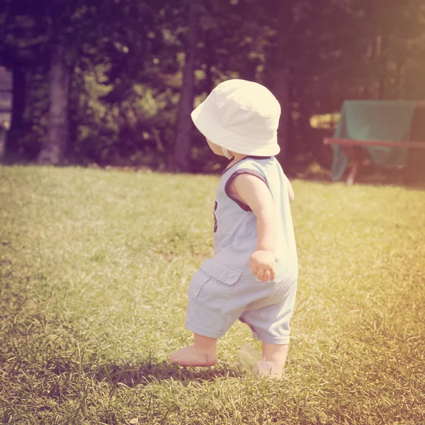 Liten pojke går i gräset — Stockfoto