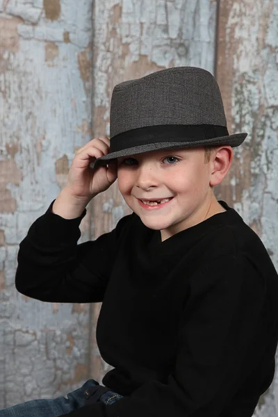 Маленький мальчик держит шляпу в старой пустой комнате — стоковое фото