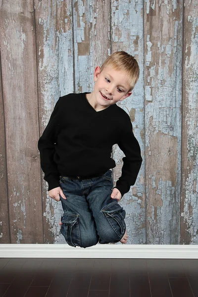 Liten pojke hoppar i gamla tomt rum — Stockfoto