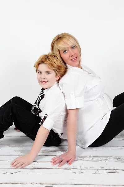 Boy and pregnant mother sitting on floor — Stock Photo, Image
