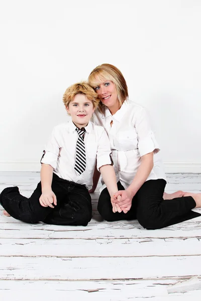 Boy and pregnant mother sitting on floor — Stock Photo, Image