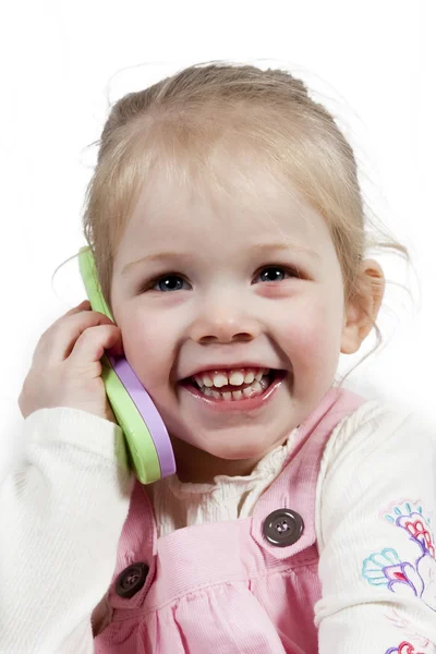 Очаровательная девочка с игрушечным телефоном — стоковое фото