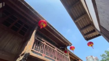 Geleneksel Asya ahşap binalarının alçak açılı dönüşlü görüntüleri, fenerleri sallanan çatı sazlıkları ve üst kattaki balkon balkonları, Fuzhou, Fujian, Çin