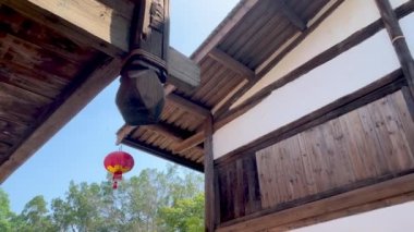 Geleneksel Asya ahşap binalarının alçak açılı dönüşlü görüntüleri, fenerleri sallanan çatı sazlıkları ve üst kattaki balkon balkonları, Fuzhou, Fujian, Çin