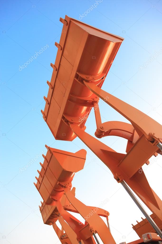 The buckets of heavy construction machine raised against