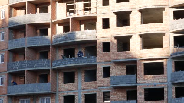 建筑工人 装配工和焊工正在一座在建的砖楼里工作 — 图库视频影像