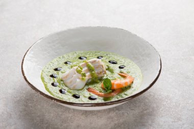 Kabak kreması ve balzamik sirke üzerine balık filetosu ve karides.