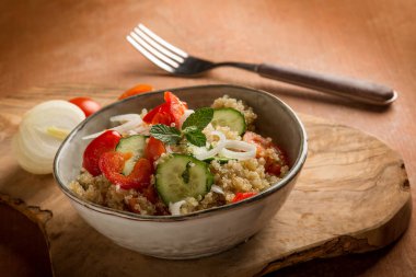 quinoa salad with tomatoes pepper cucumber onion and mint leaf
