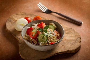 quinoa salad with tomatoes pepper cucumber onion and mint leaf