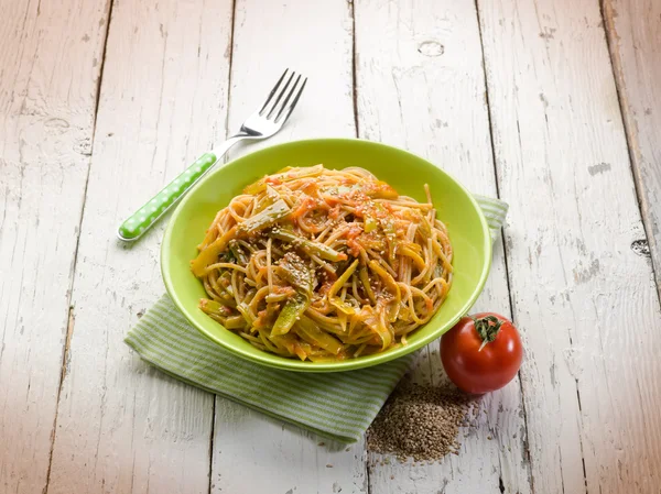 Spaghetti med tomater grön paprika och sesamfrön — Stockfoto