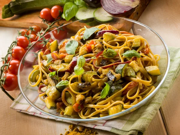 Pasta with eggplants zucchinis tomatoes and curry — Stock Photo, Image