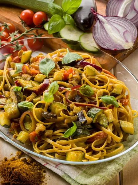 Pasta with eggplants zucchinis tomatoes and curry — Stock Photo, Image