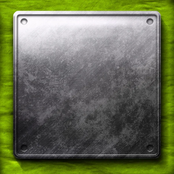Metal plate on green background — Stock Photo, Image