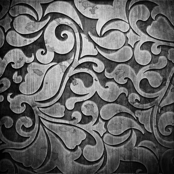 Black carved ornament on wooden texture — Stock Photo, Image