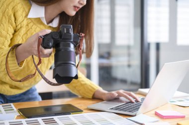 Genç fotoğrafçı bilgisayarındaki dijital kameradan görüntüleri kontrol ediyor..
