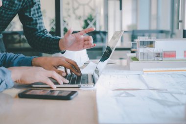 İş yerinde ortak ve mühendislik araçlarıyla çalışan mimari proje için mühendis toplantısı resmi.