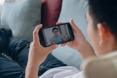 Adam dinle ve online eğitim ya da kurs izle, erkek çalışan web kamerası konferansında notlar alıyor ya da iş arkadaşıyla brifing veriyor, evinde web toplantısı yapıyor..