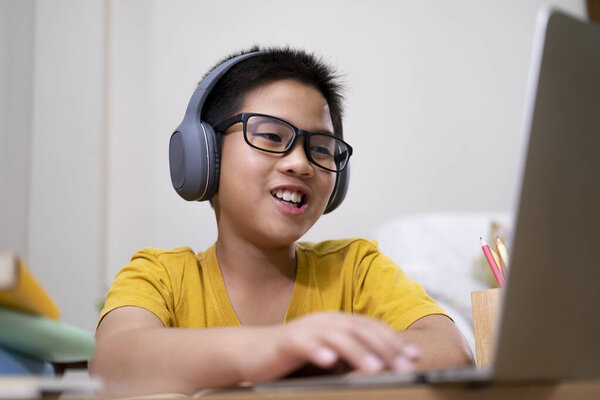 Young boy using computer and mobile device studying online. Education and online learning. 