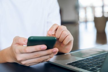 Genç adam cep telefonu kullanıyor. İş, eğitim ve iletişim için çevrimiçi bağlantı teknolojisi kullanılıyor. 