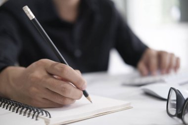 Deftere kalem yazarak ellerinizi kapatın. Eğitim kavramı.