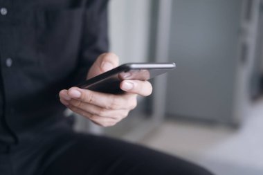 Genç adam cep telefonu kullanıyor. İş, eğitim ve iletişim için çevrimiçi bağlantı teknolojisi kullanılıyor. 