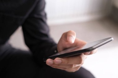 Genç adam cep telefonu kullanıyor. İş, eğitim ve iletişim için çevrimiçi bağlantı teknolojisi kullanılıyor. 