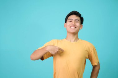 Kendine güvenen genç bir adam, yüzünde bir gülümsemeyle, kendini gururlu ve mutlu olarak gösterir..