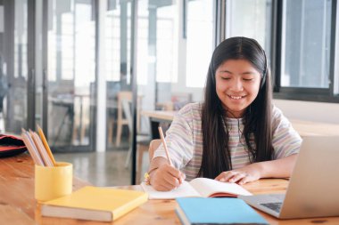 Bilgisayar ve mobil cihaz kullanan genç bir kolaj öğrencisi. Eğitim ve çevrimiçi öğrenim. 