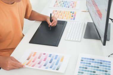Grafik tasarımcısı seçim için renk örnekleriyle çalışıyor. Grafik tasarımcısı iş başında. Renk örnekleri. Genç fotoğrafçı ve grafik tasarımcısı ofiste çalışıyor..