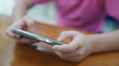 Kapanış kızı elleri mesaj atmak için akıllı telefon kullanıyor ya da telefonunda oyun oynuyor. Dijital bağımlılık kavramı. Modern dünyada toplumun dijital hale getirilmesi ve bilgilendirilmesi.