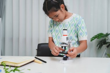 BTMM merakını destekleyen mikroskop kullanarak bitki araştırması yapan öğrenci ve dijital öğrenme büyümesi