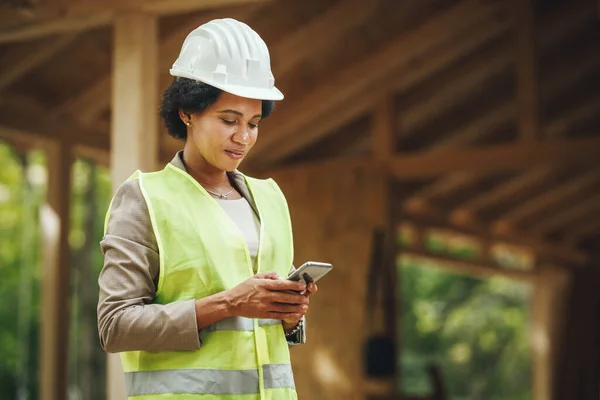 Tiro Uma Arquiteta Africana Usando Smartphone Verificando Local Construção Uma — Fotografia de Stock