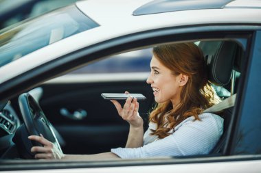 Çekici bir iş kadınının sabah trafiği sıkışıkken akıllı telefondan konuşması..