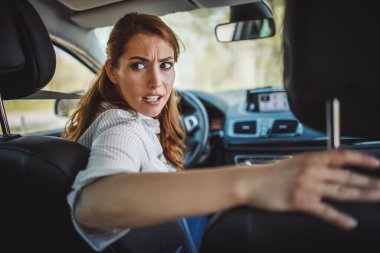 Stresli bir iş kadınının sabah trafiğinde arabasını sürerken görüntüsü..