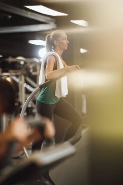 Çekici bir genç kadının spor salonundaki merdivenlerde egzersiz yaparken çekilmesi..