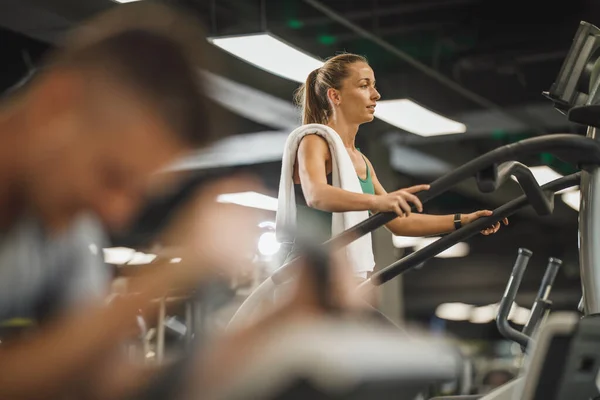 在健身房的跑步机上锻炼的年轻女子中枪 — 图库照片