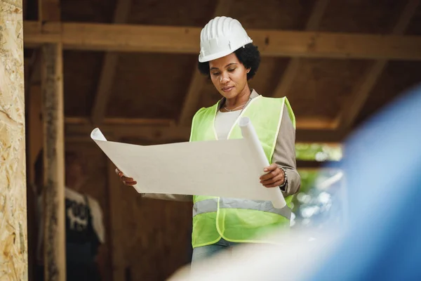 Shot African Female Architect Checking Blueprints Construction Site New Wooden — Stock Photo, Image