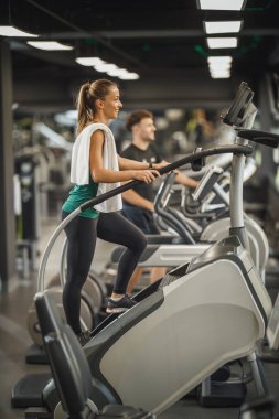 Çekici bir genç kadının spor salonundaki merdivenlerde egzersiz yaparken çekilmesi..
