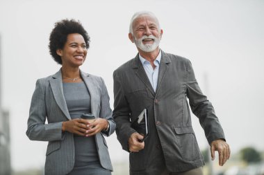 İki başarılı çoklu etnik iş adamının kahve molası sırasında yürürken konuşması..