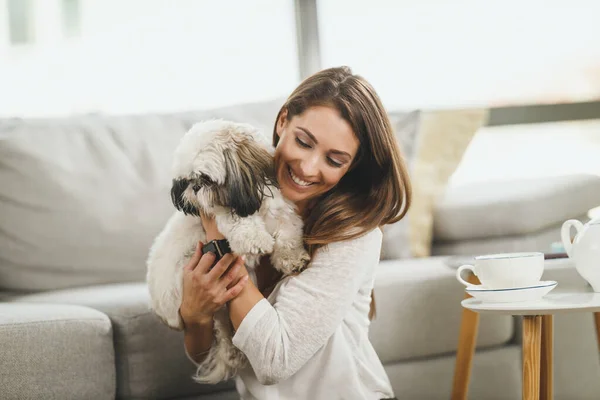 可愛いです若いです女性リラックスペット犬で彼女のリビングルームにザ — ストック写真